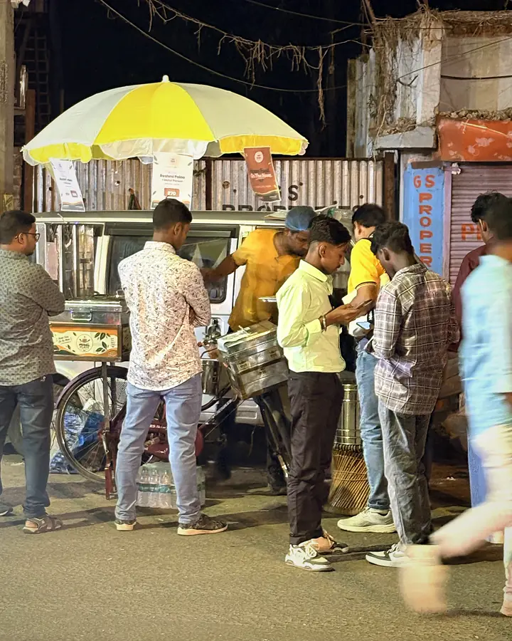 Customers queuing at the Pedal Plate cart under its yellow umbrella